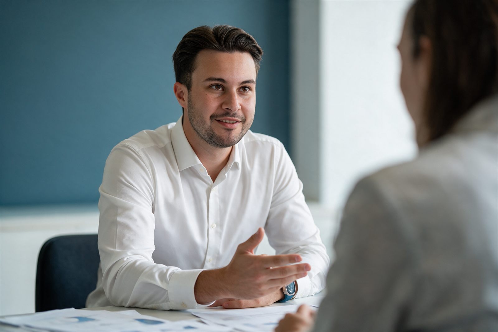 Beratungsgespräch am Besprechungstisch, Unterlagen liegen aufgeschlagen bereit